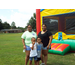 two adults with two children standing in front of a bouncy house